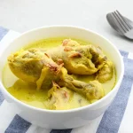 Opor ayam gurih dengan kuah kental santan dan taburan bawang goreng