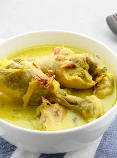 Opor ayam gurih dengan kuah kental santan dan taburan bawang goreng